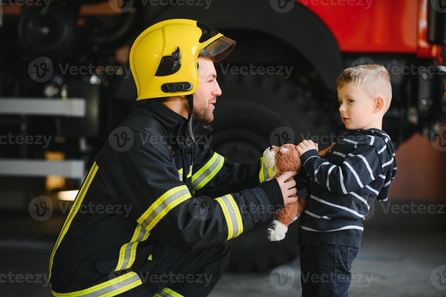 Firefighter holding child boy to save him in fire and smoke,Firemen rescue the boys from fire photo