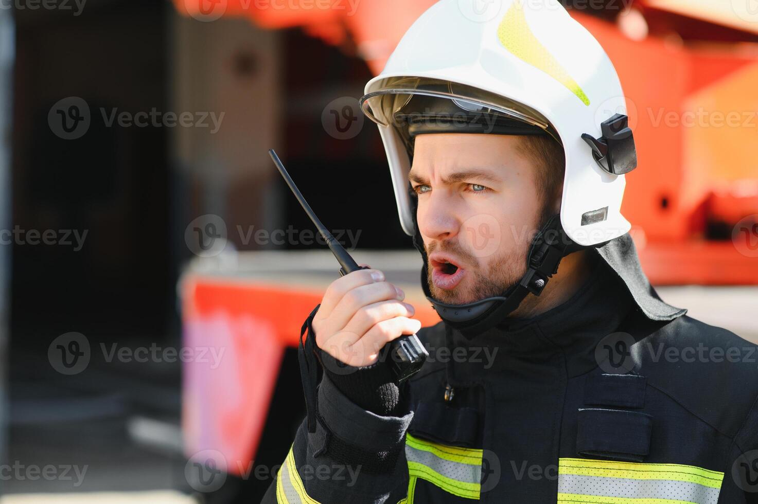 Fireman, firefighter in action standing near a firetruck. Emergency safety. Protection, rescue from danger. photo