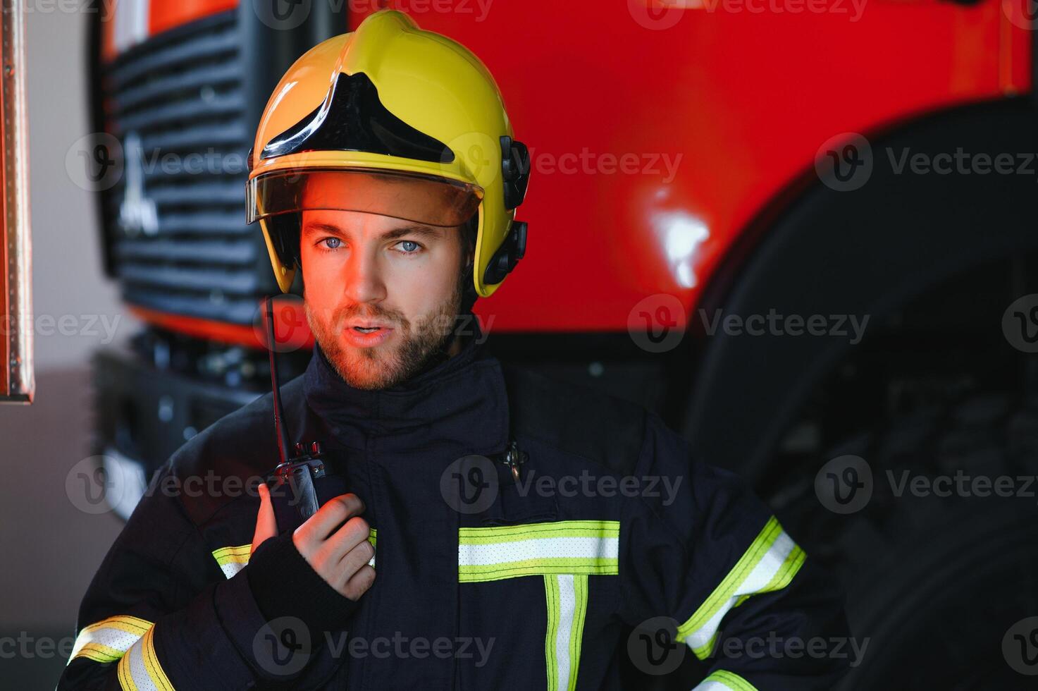 Firefighter portrait on duty. Photo fireman with gas mask and helmet near fire engine.