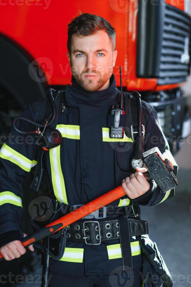 Photo of fireman with gas mask and helmet near fire engine