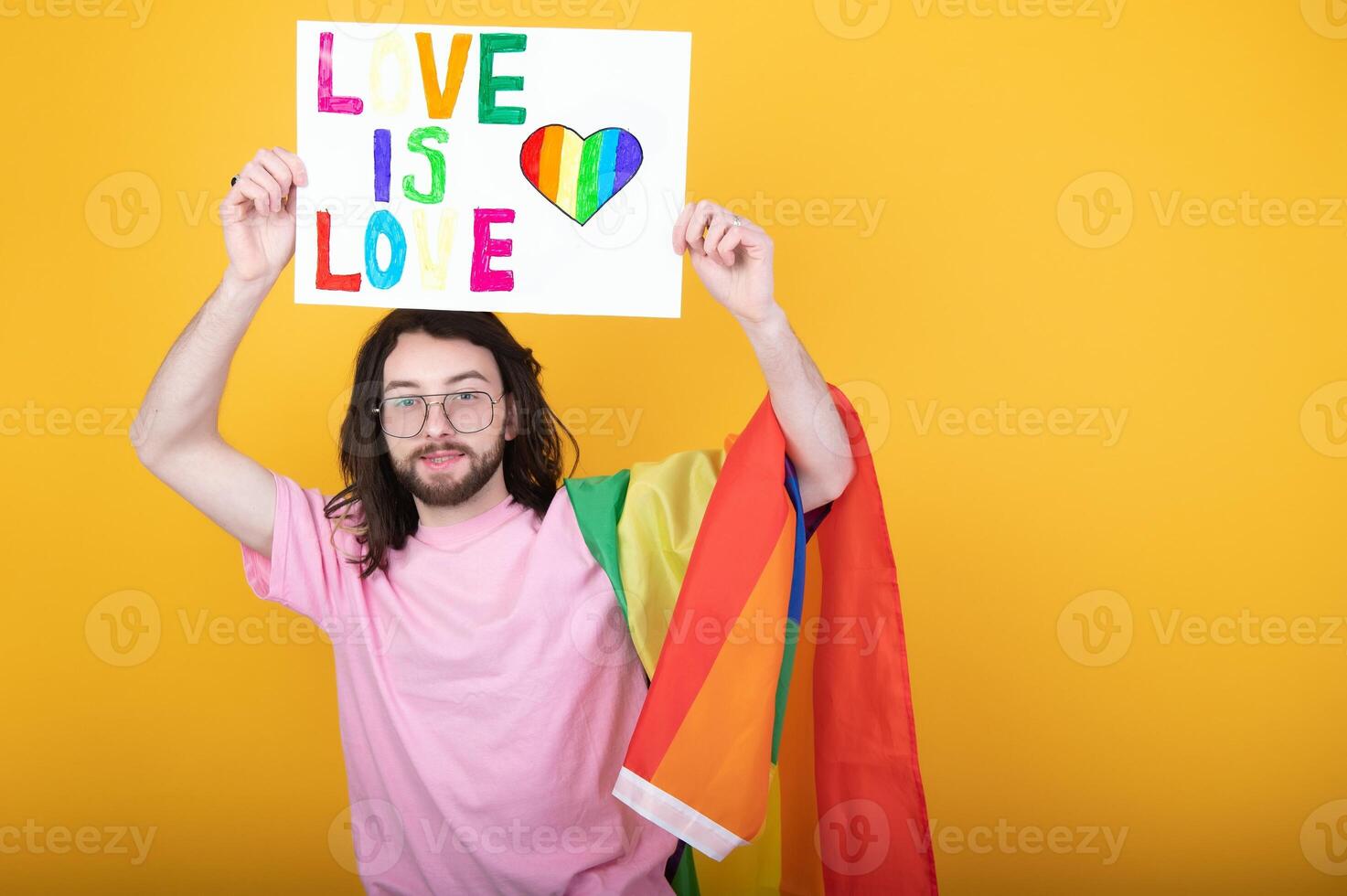 Hands of gay man holding lgbt banner on rainbow flag background lgbt symbol photo