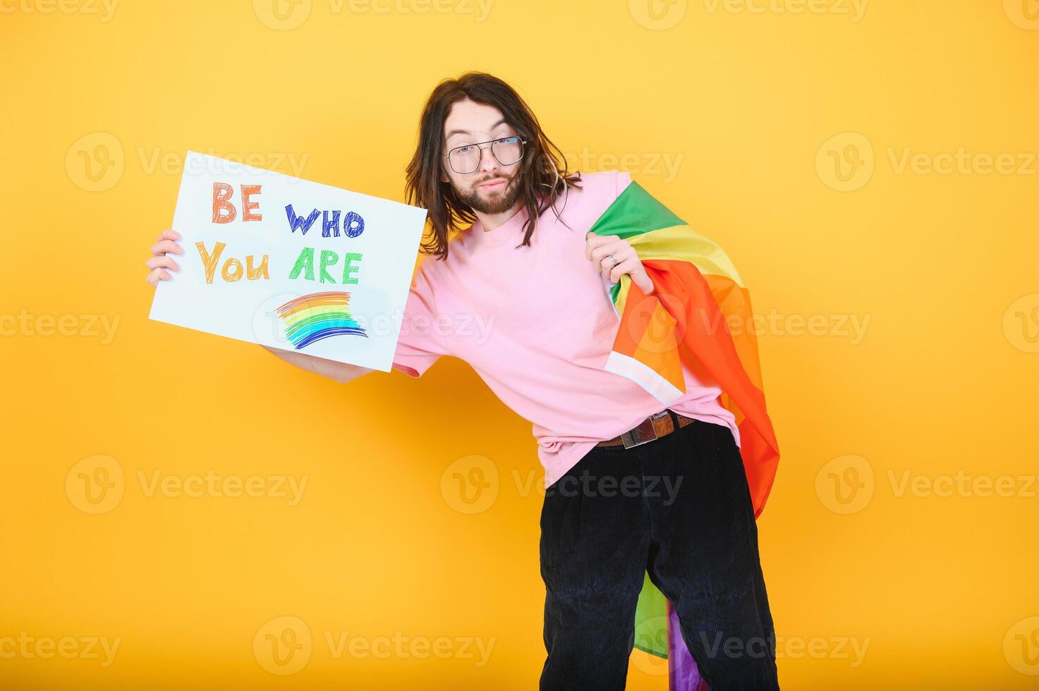 Hands of gay man holding lgbt banner on rainbow flag background lgbt symbol photo