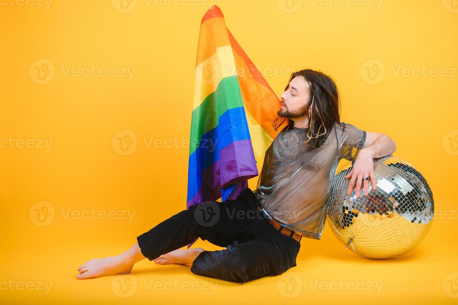 Young gay man is standing in the studio and posing for a camera. photo