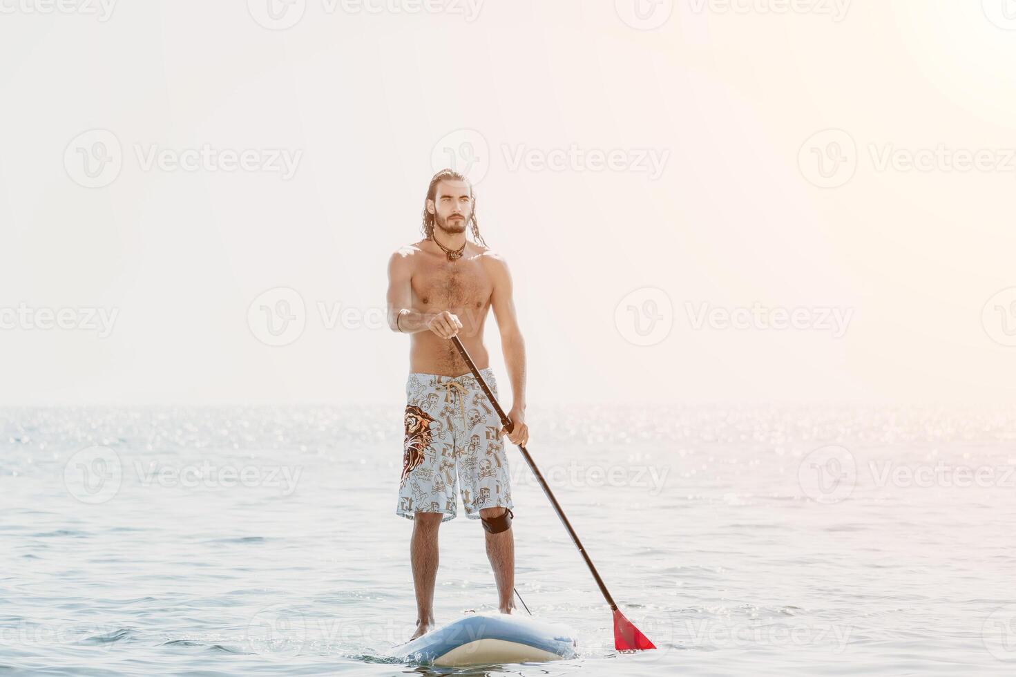 Man Sup Sea. Strong athletic man learns to paddle sup standing on board in open sea ocean on sunny day. Summer holiday vacation and travel concept. Aerial view. Slow motion photo