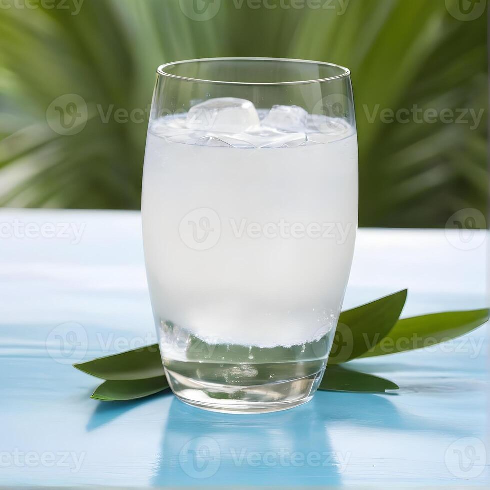 A glass of coconut water with leaf. Tropical summer drink. photo