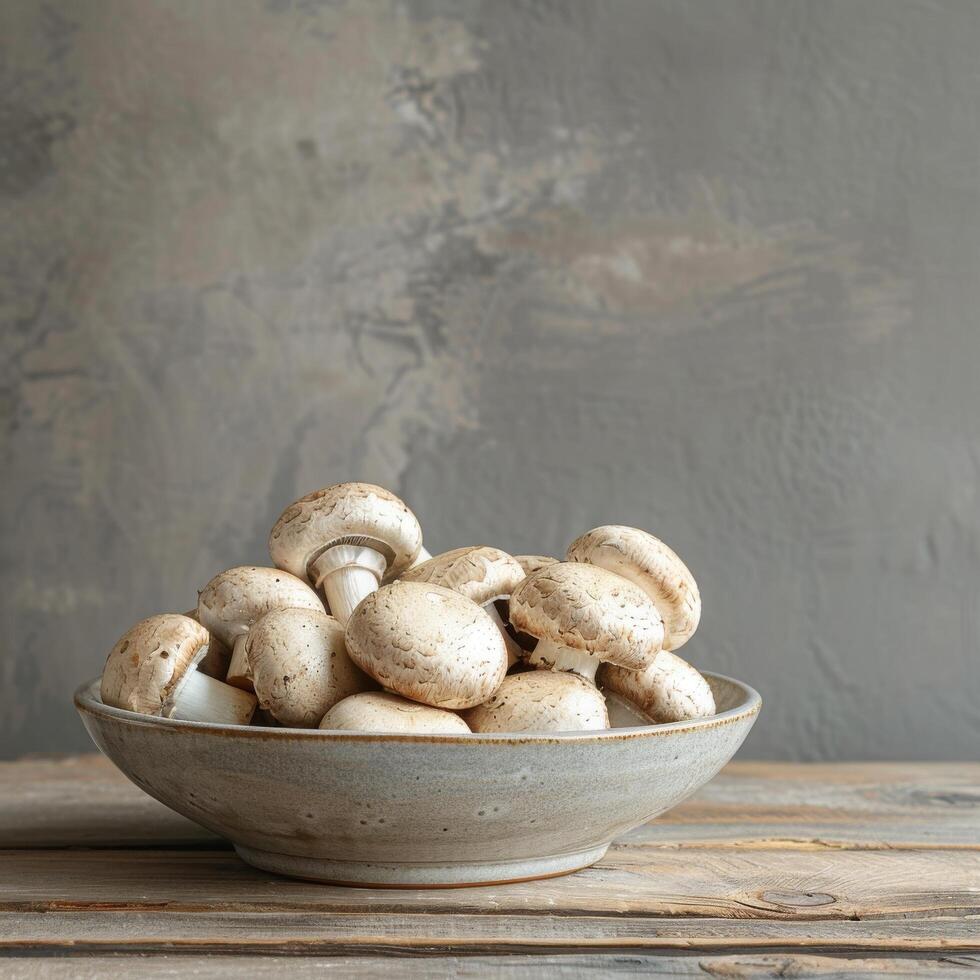 White Button Mushrooms in a Gray Bowl on a Wooden Table photo