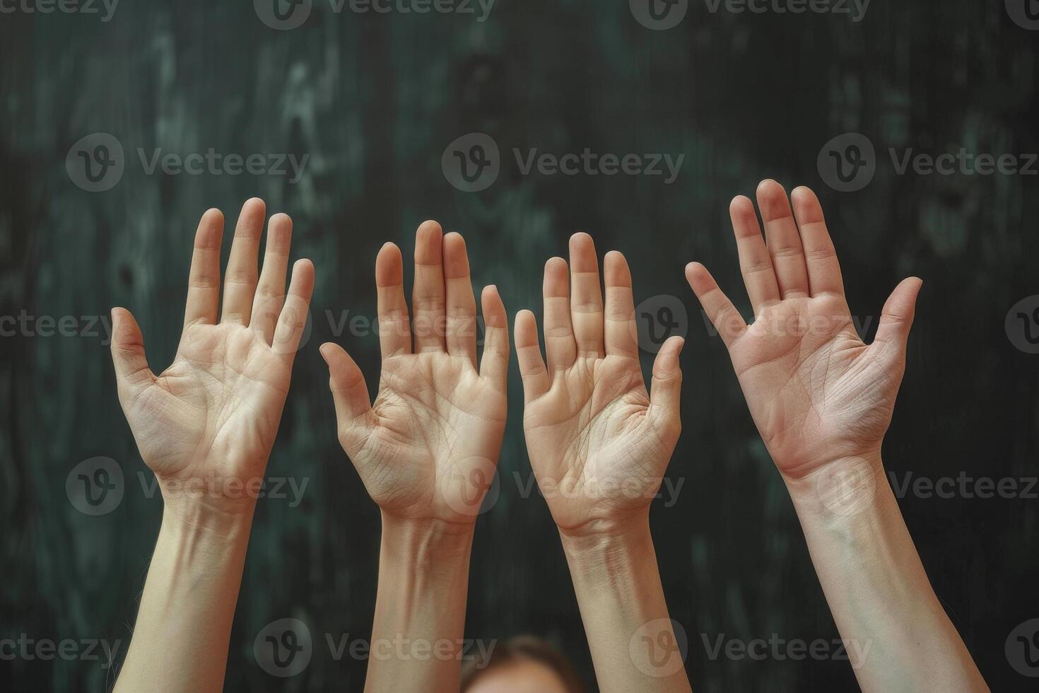 Hands Raised In Solidarity Against a Dark Background photo