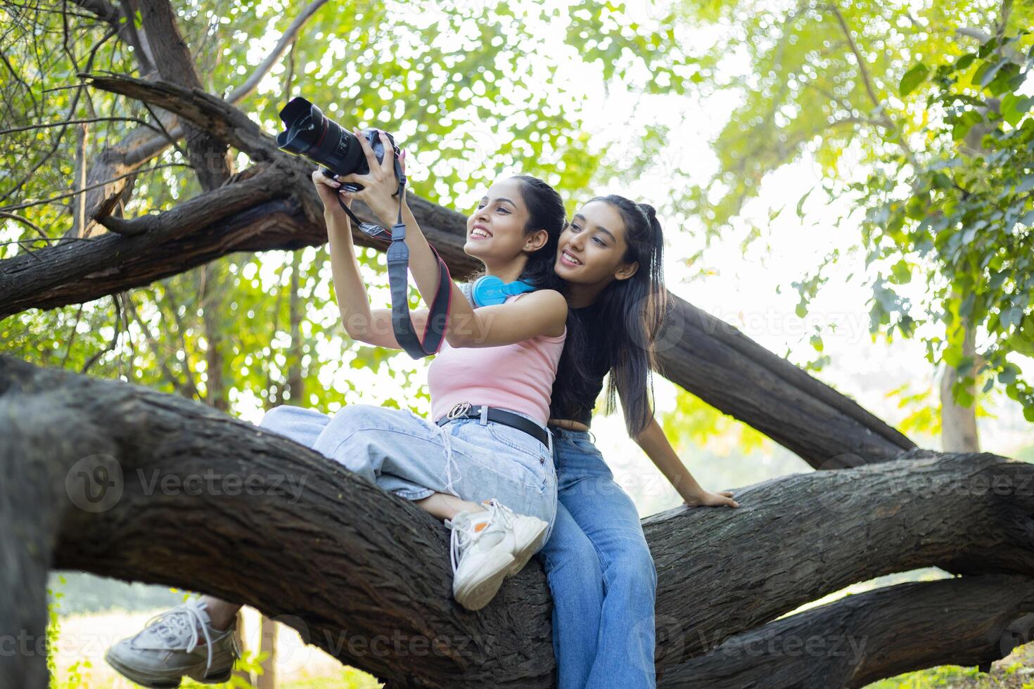 Two female friends examining her photographs taken with a DSLR camera photo