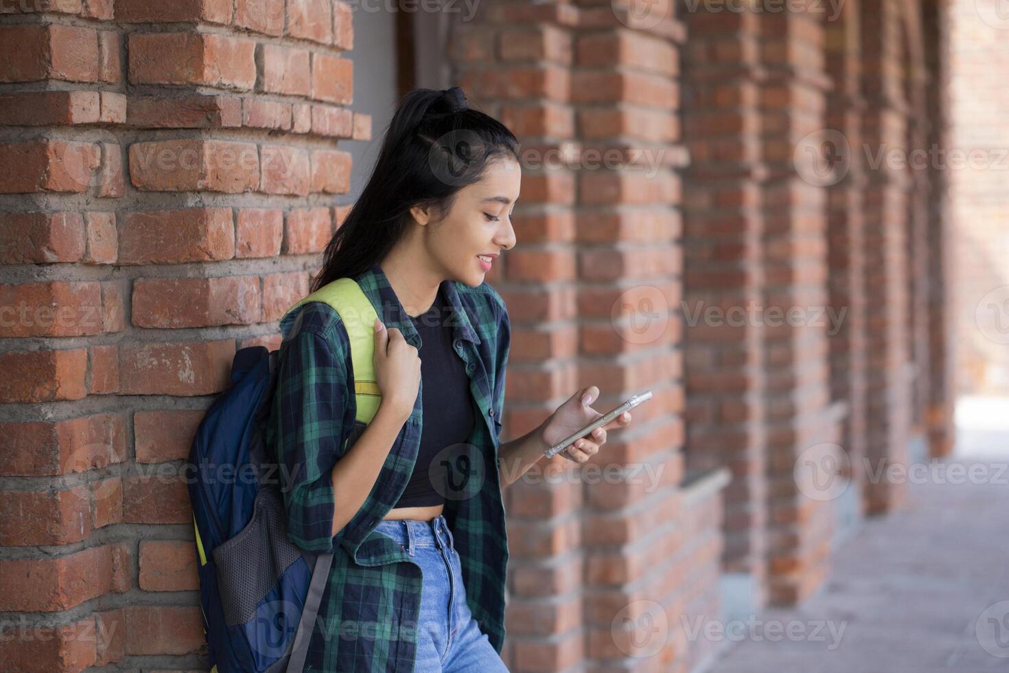 Female Academy Student is Scrolling the Phone in College Campus photo