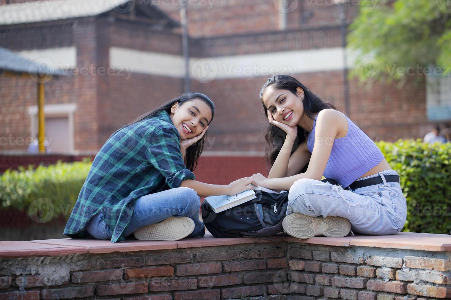 Two Innocent Friends Looking At the Camera With Both Hands Under Their Chin photo