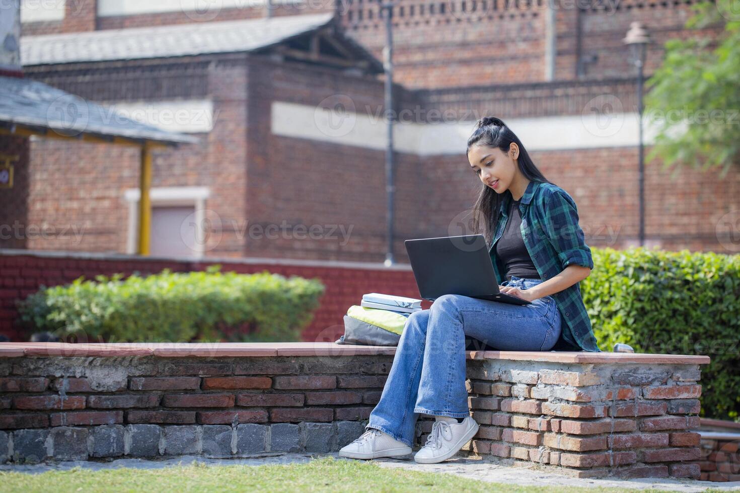 Lovable Girl Sitting On Campus With a Laptop photo