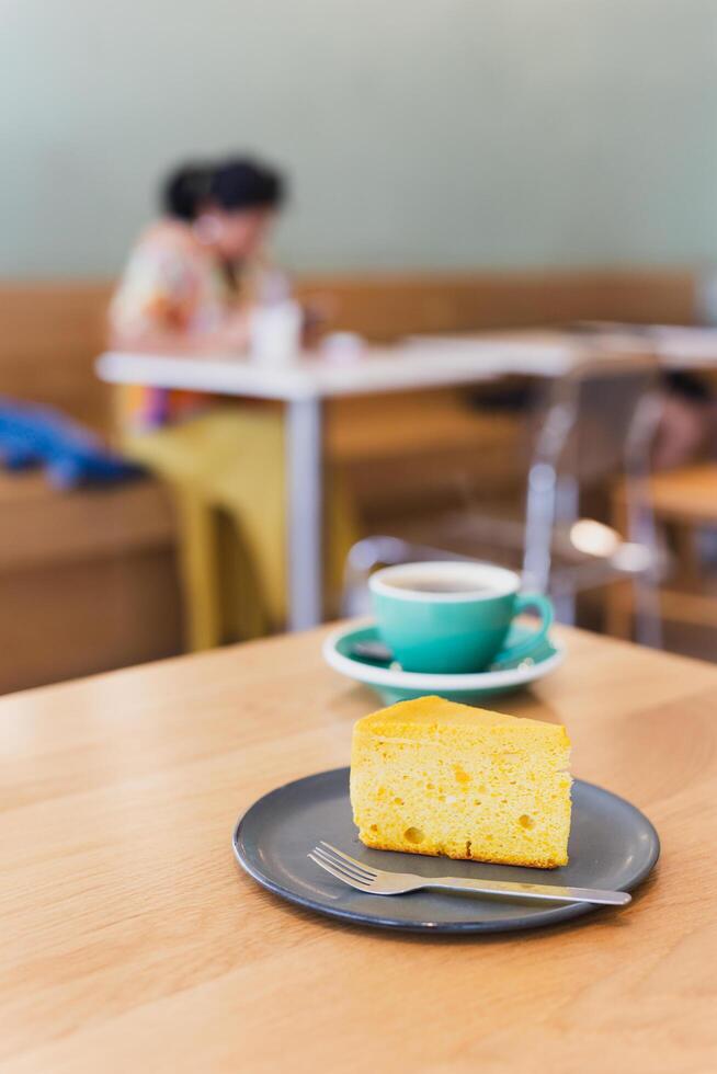 Slice of homemade sponge cake with cup of coffee on table. photo
