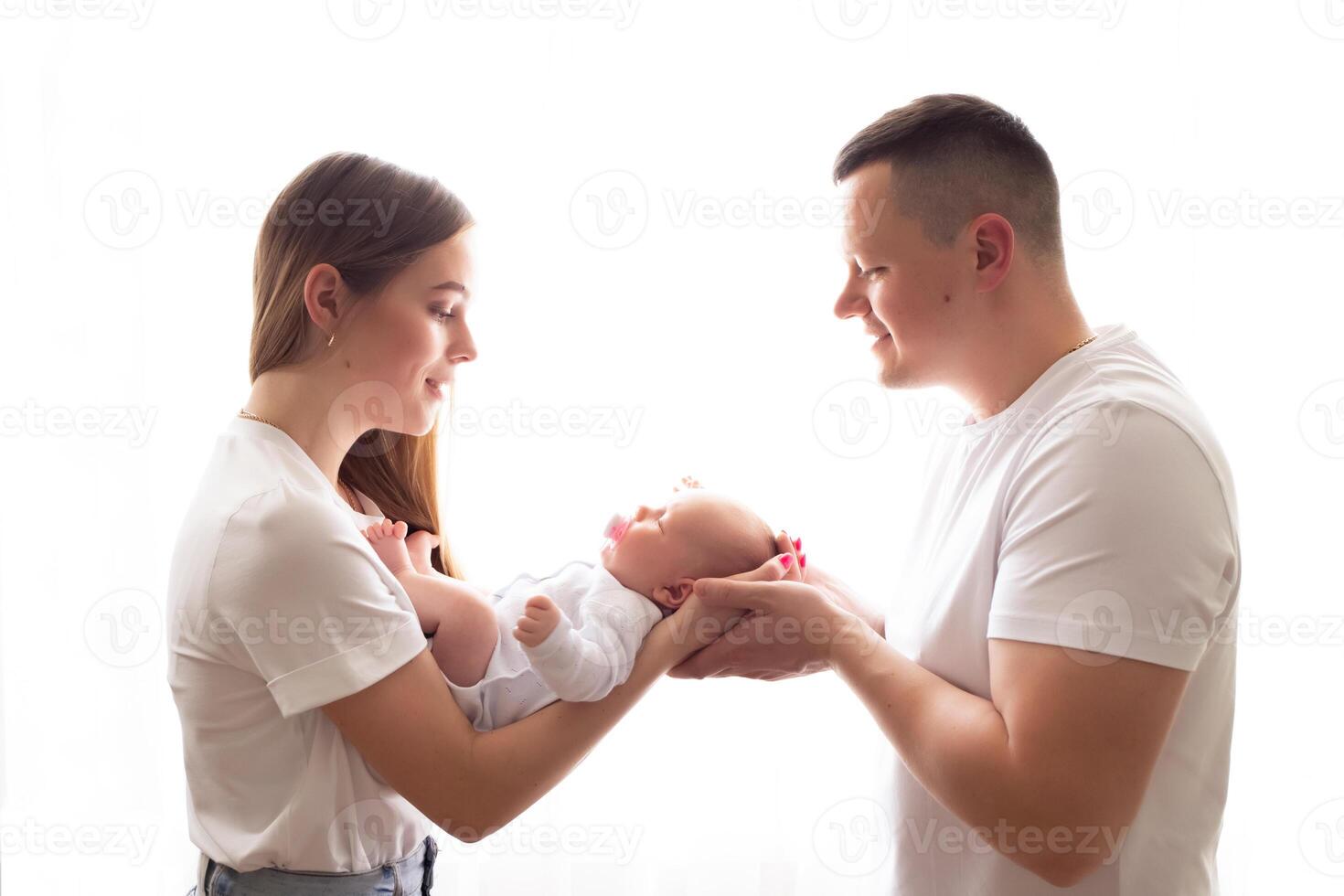 young parents hold the baby in their arms. family lifestyle photo with baby. family concept. family photo on white background