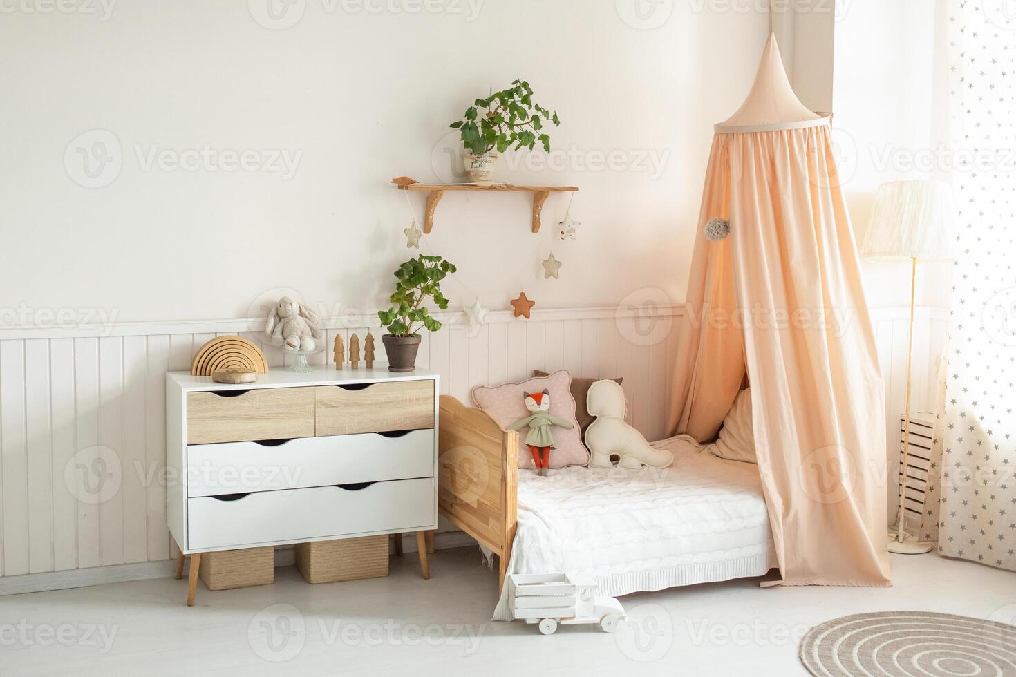 a cozy and bright children's room with a four-poster bed, a chest of drawers, a floor lamp and cute soft toys. light background photo