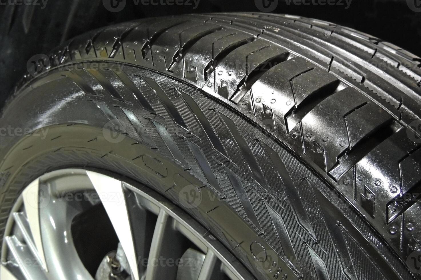 Polished sidewall of car tire on the alloy wheel rim close up photo
