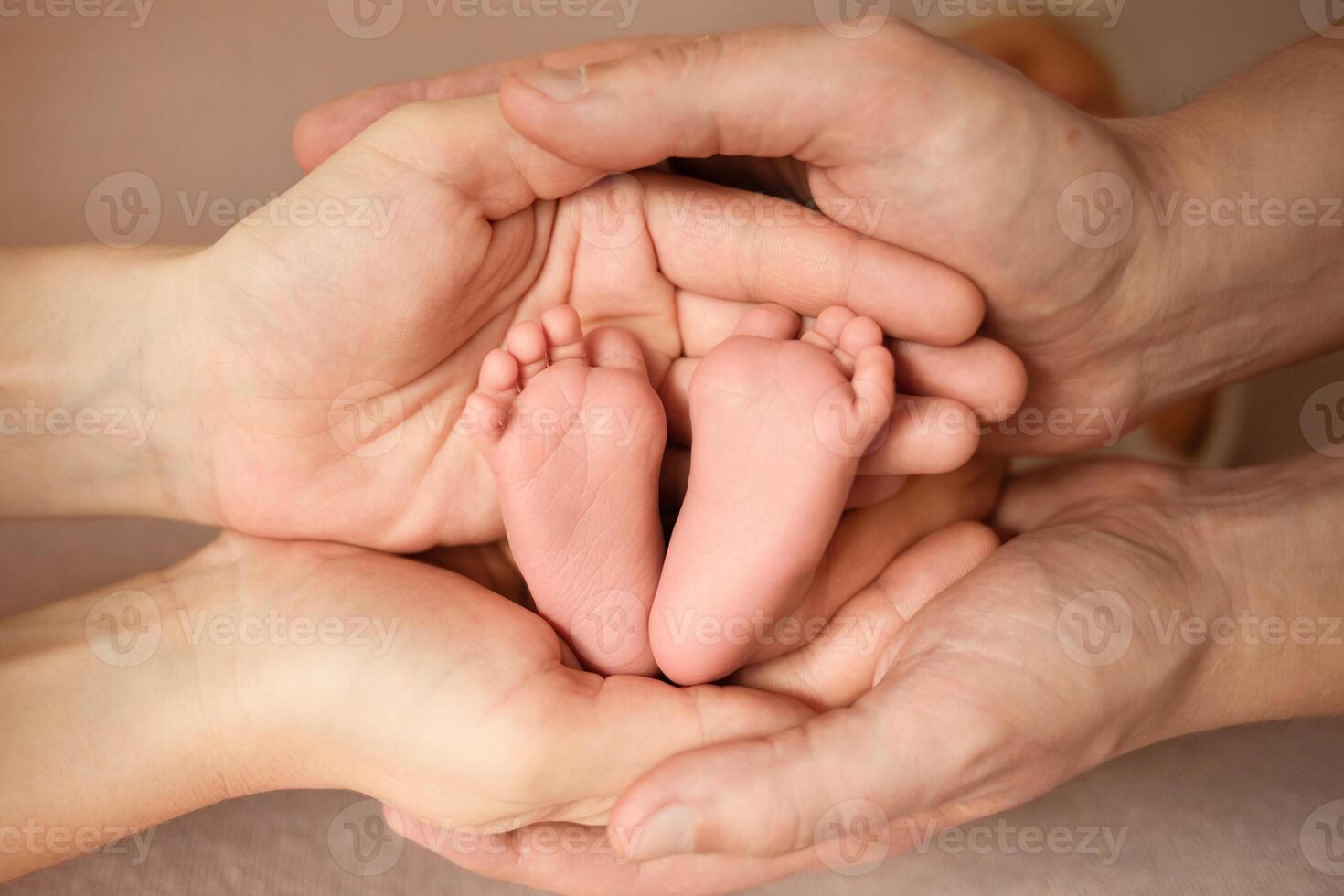 the parent's hand holds the baby's small leg, light close-up photo. family concept. background with place for text photo