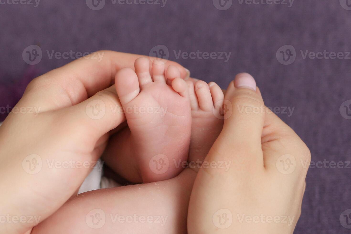 the parent's hand holds the baby's small leg, light close-up photo. family concept. background with place for text. photo