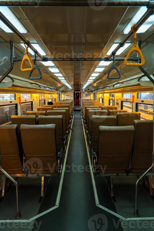 Public trains in Java, Indonesia are empty of passengers in the afternoon when the sun sets. The train carriage was quiet and many passenger seats were empty photo