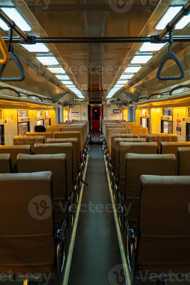Public trains in Java, Indonesia are empty of passengers in the afternoon when the sun sets. The train carriage was quiet and many passenger seats were empty photo