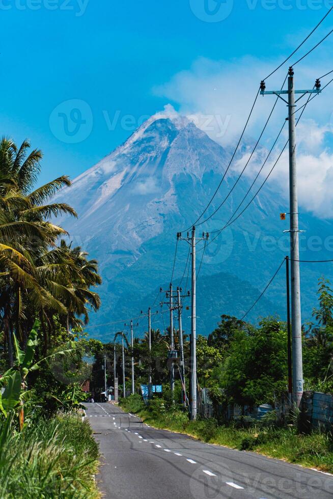 Mount Merapi in Indonesia in the afternoon is very clear and majestic from a distance. Panorama of mountains with a blue sky background on a sunny day photo