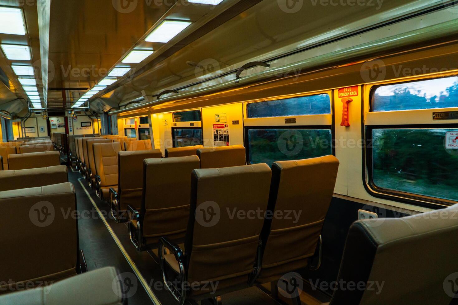 Public trains in Java, Indonesia are empty of passengers in the afternoon when the sun sets. The train carriage was quiet and many passenger seats were empty photo