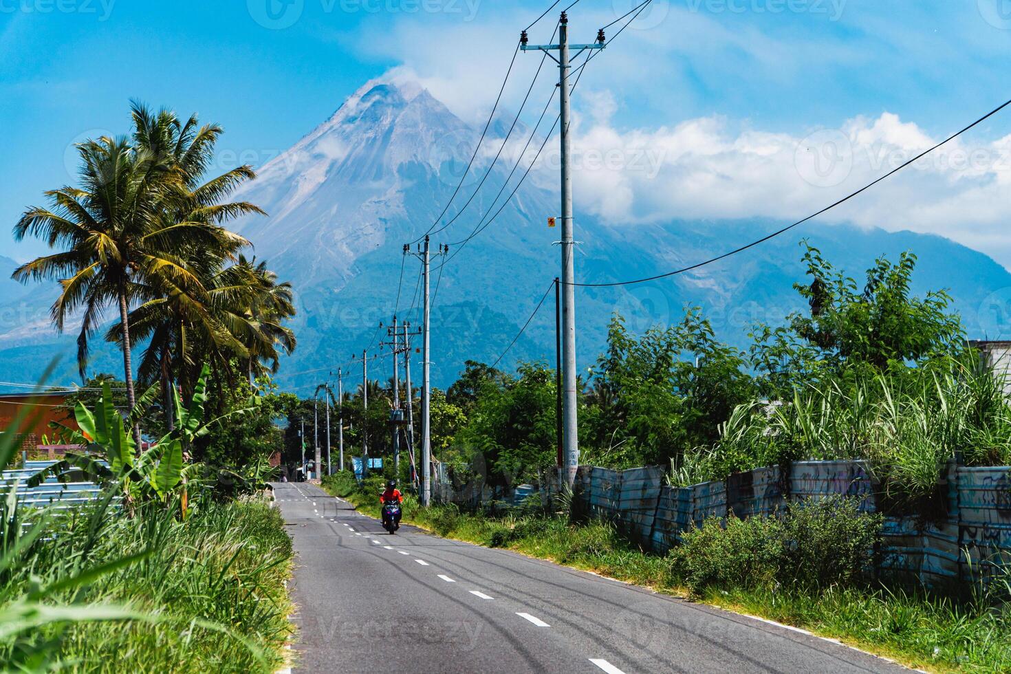 Mount Merapi in Indonesia in the afternoon is very clear and majestic from a distance. Panorama of mountains with a blue sky background on a sunny day photo