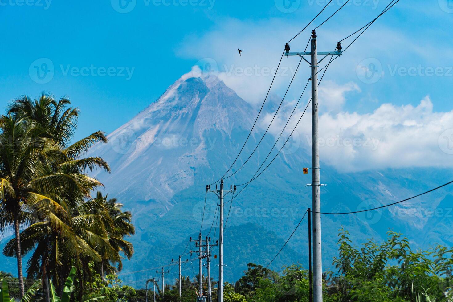 Mount Merapi in Indonesia in the afternoon is very clear and majestic from a distance. Panorama of mountains with a blue sky background on a sunny day photo