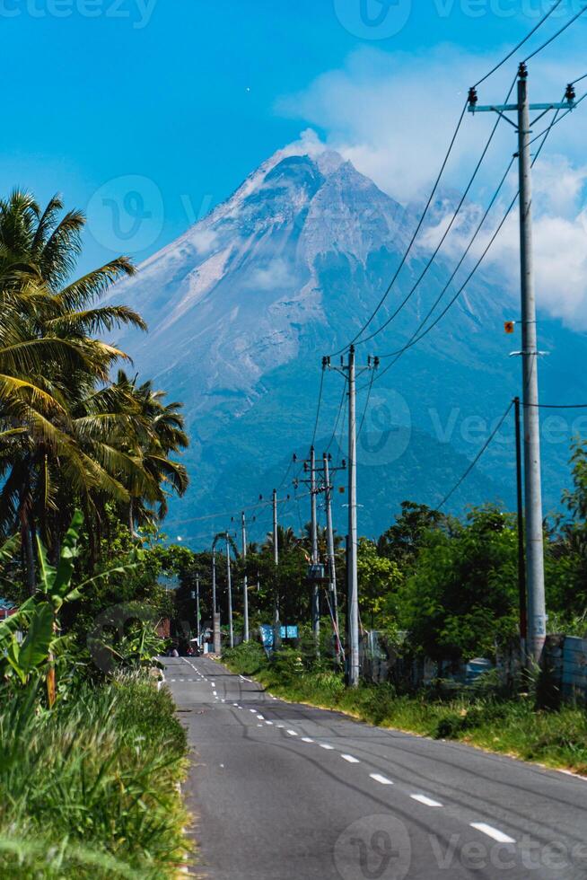 Mount Merapi in Indonesia in the afternoon is very clear and majestic from a distance. Panorama of mountains with a blue sky background on a sunny day photo