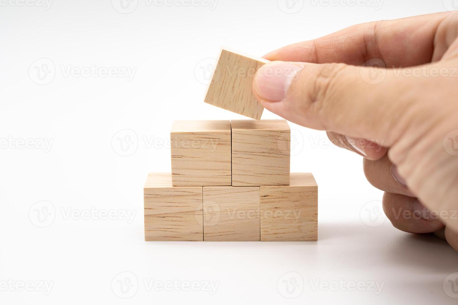 Hand putting and stacking blank wooden cubes on white background with copy space for input wording and infographic icon. photo