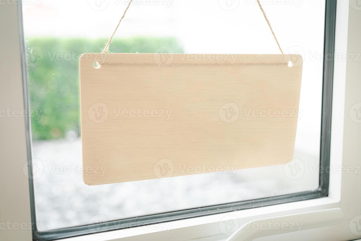 Blank wooden sign board hanging on window. sign broad through the door glass for text. copy space photo