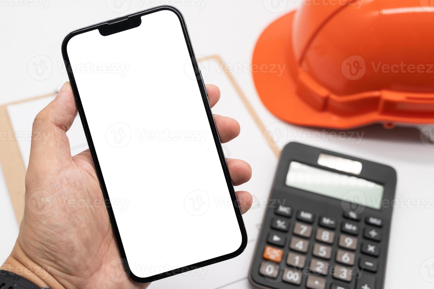 Engineering using phone mobile on desk. White empty screen for your advertise on Smartphone. Blank Smartphone screen On engineering working desk for application mock up template. photo