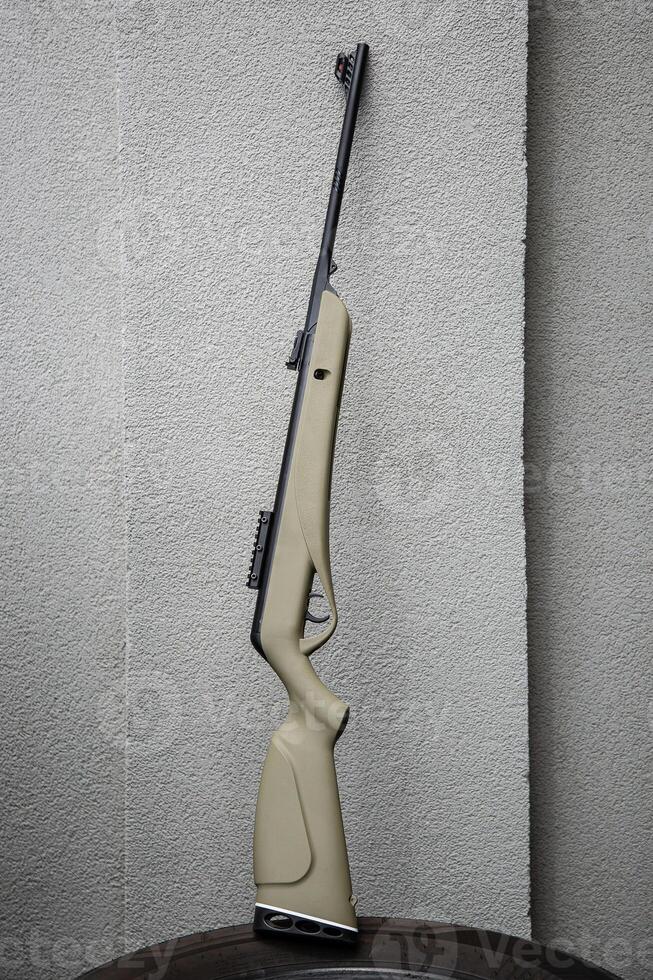 Modern air rifle. Air guns for sports and entertainment. Gray concrete back photo