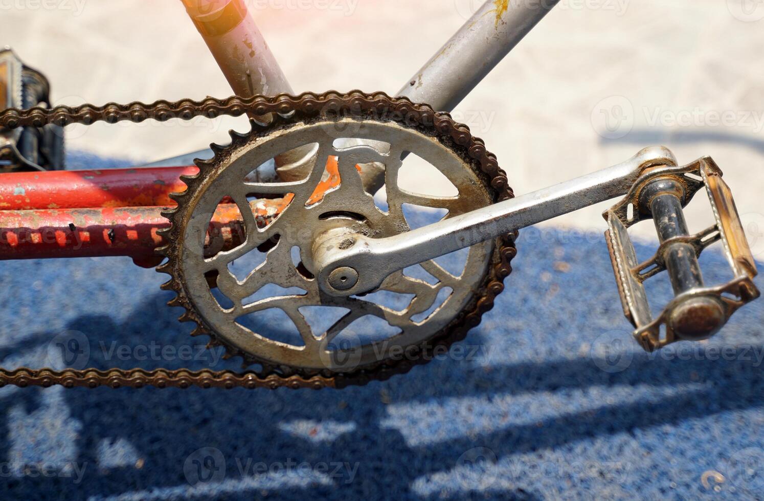 The old chains and pedals of antique tricycles that have been sitting there for so long are rusting. photo