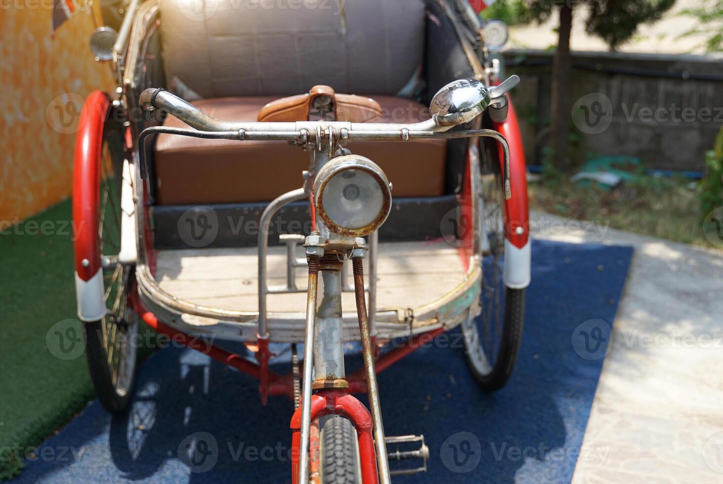 Front view of old ancient Thailand tricycle. The structure is made of strong metal, with a headlight, handlebars, bell, and rider seat. passenger seat It is beautifully designed. photo