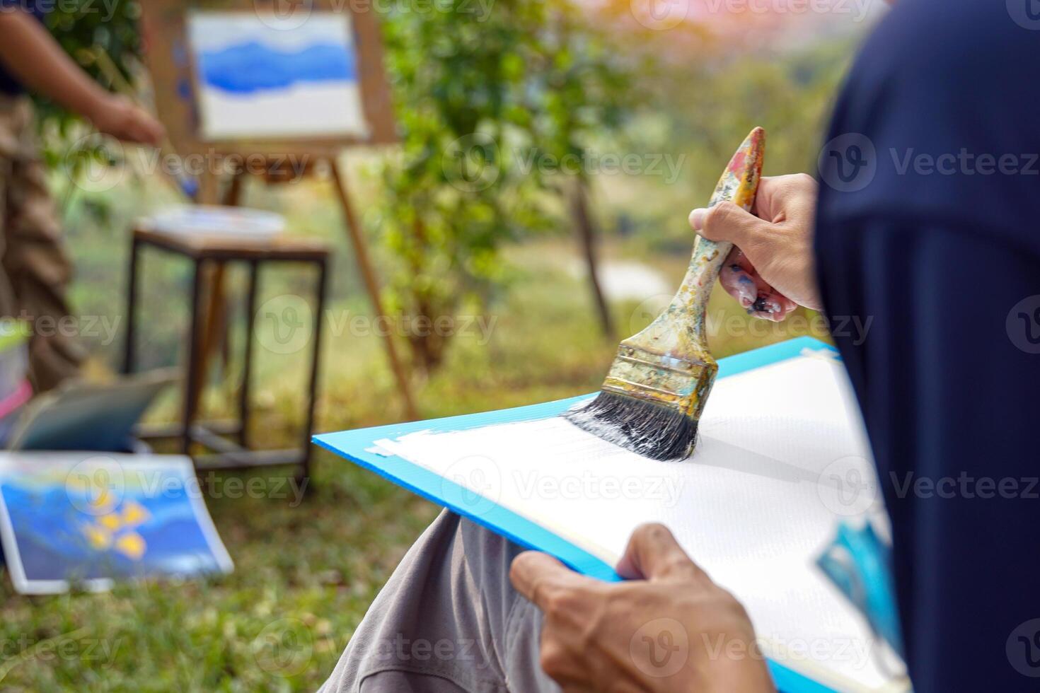The students used paint brushes to color the distant mountain ranges from light blue to dark blue. Follow the example the teacher gives you. soft and selective focus. photo