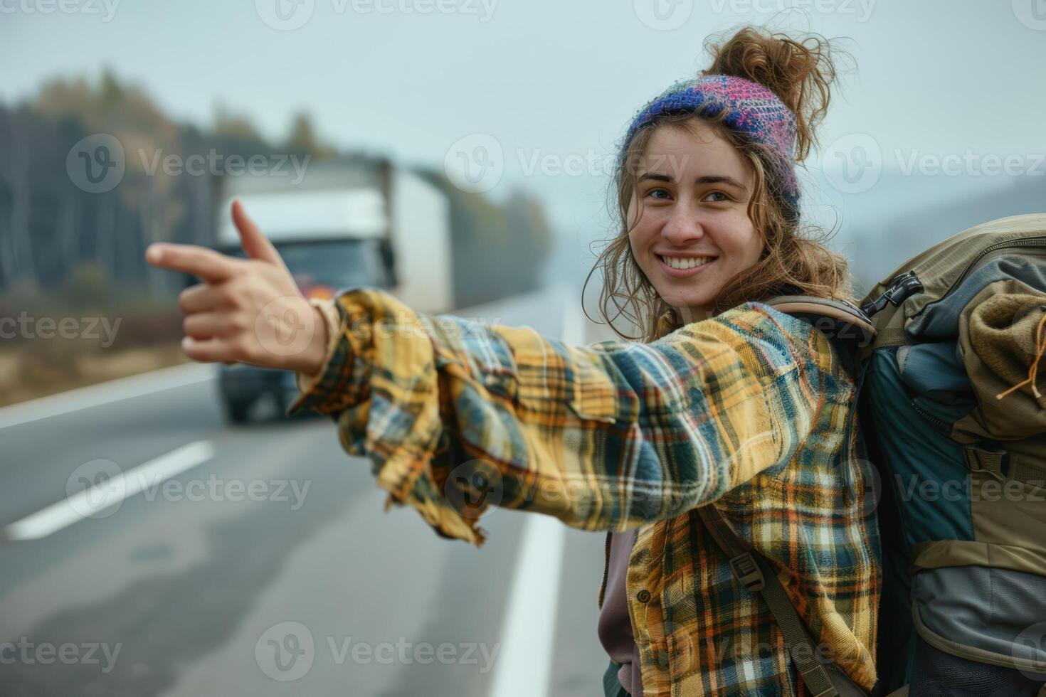 a woman with a backpack pointing at the camera photo