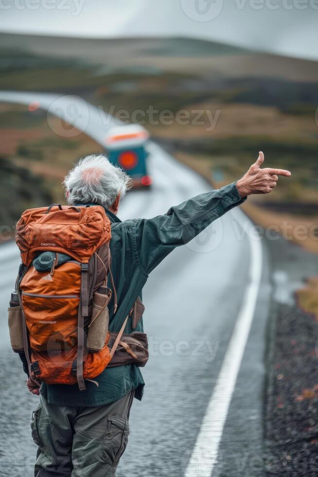 senior man with backpack on road pointing to bus photo