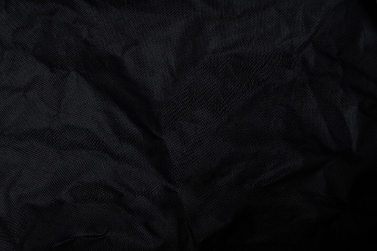 Black crumpled paper with shadow for background. wrinkled surface, design, wallpape photo