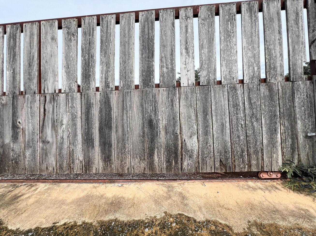 Weathered Wooden Fence with Concrete Base photo