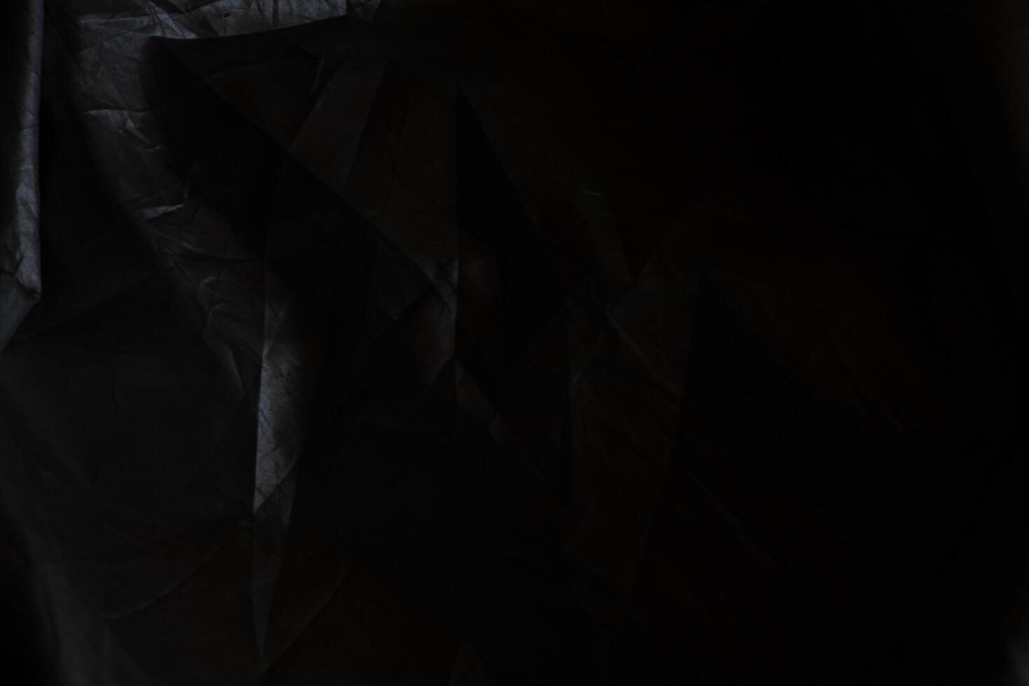 Black crumpled paper with shadow for background. wrinkled surface, design, wallpape photo