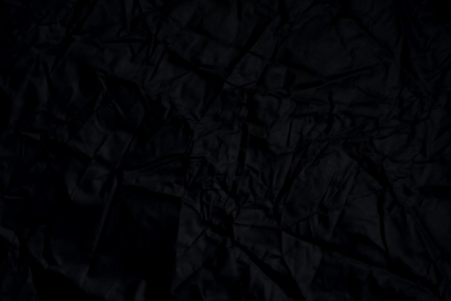 Black crumpled paper with shadow for background. wrinkled surface, design, wallpape photo