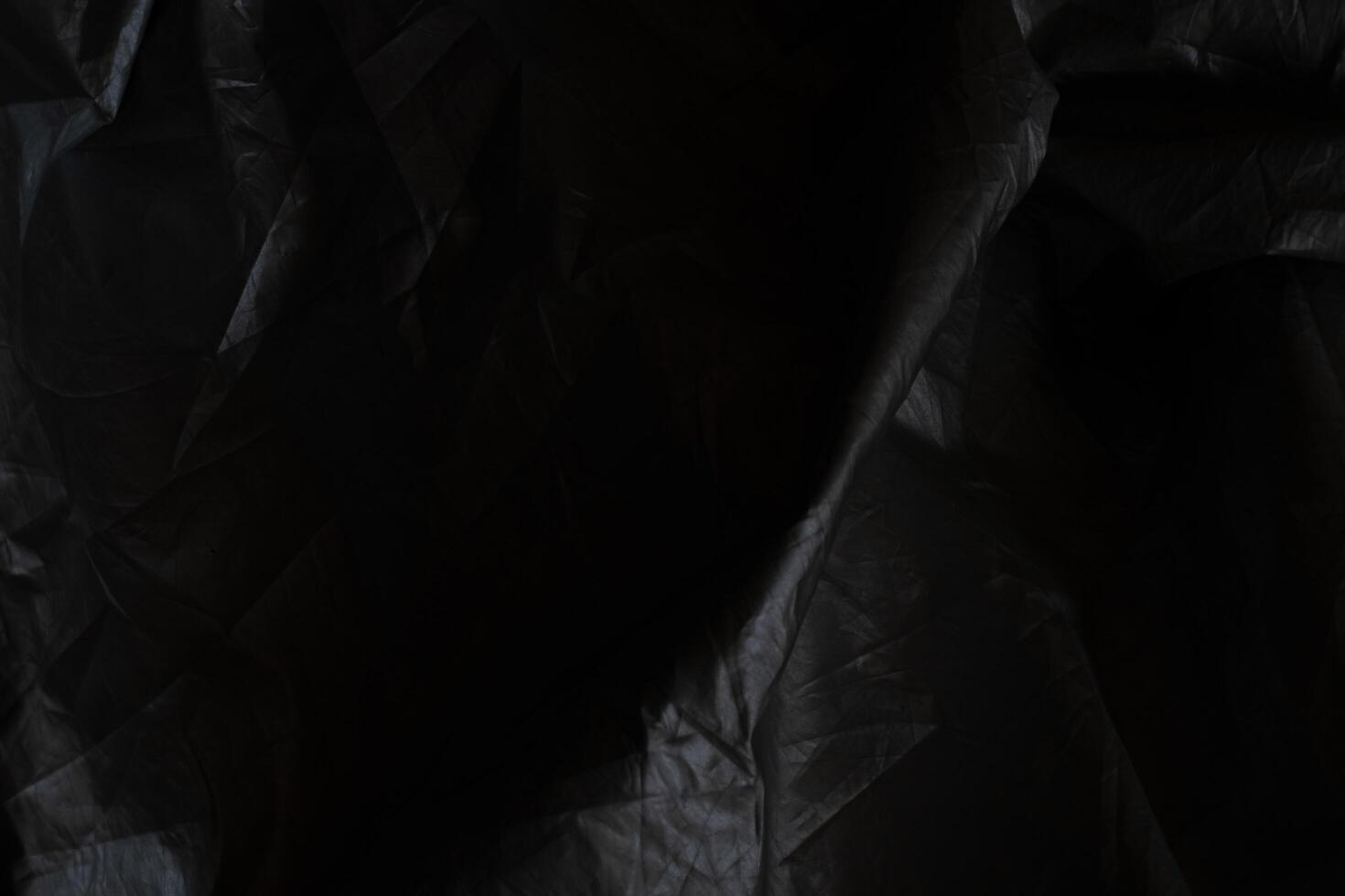 Black crumpled paper with shadow for background. wrinkled surface, design, wallpape photo
