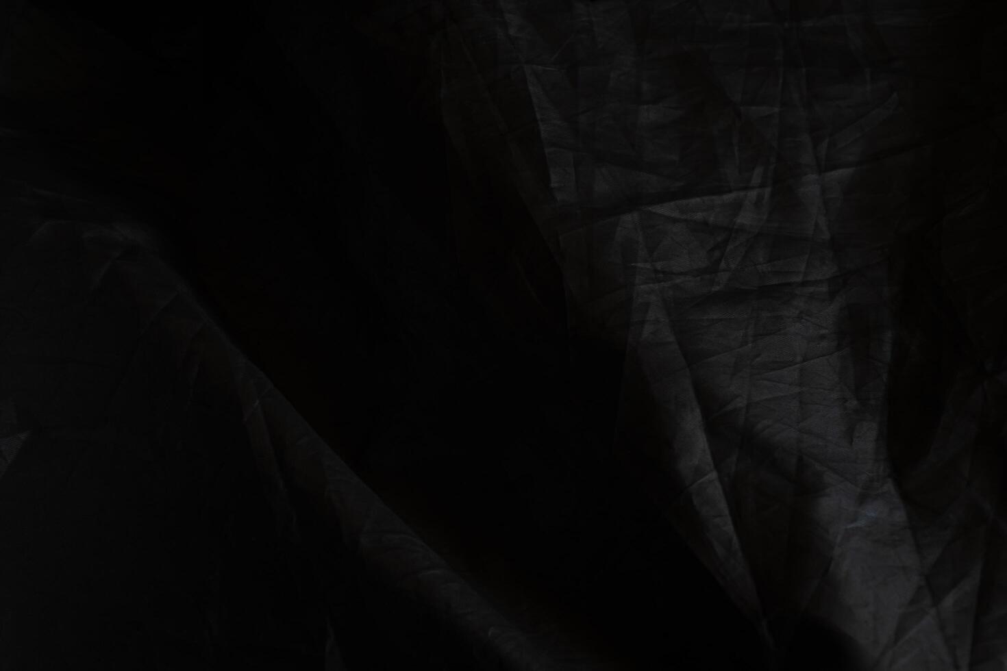 Black crumpled paper with shadow for background. wrinkled surface, design, wallpape photo