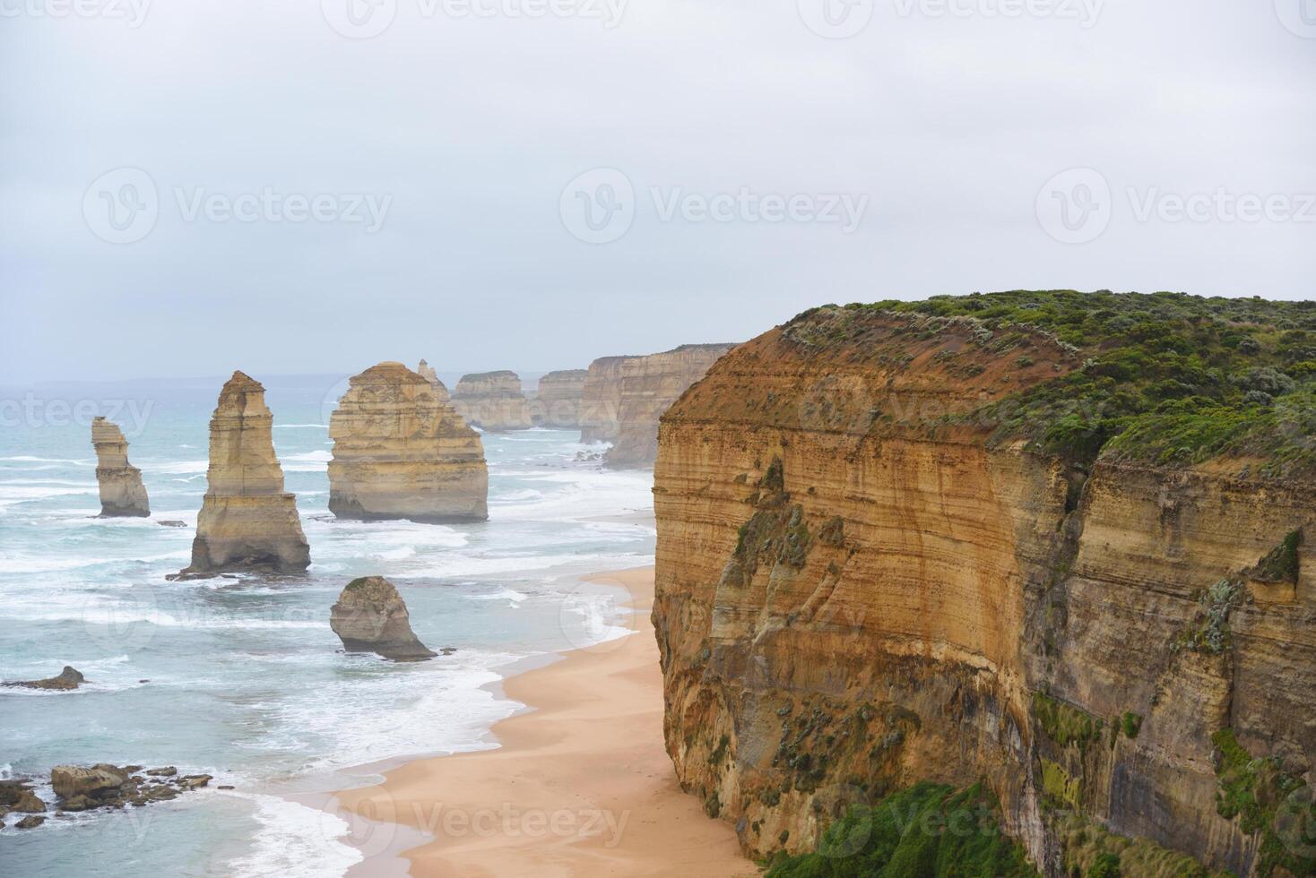 View of the 12 Apostles in cloudy day, Erosion of the mainland coast's limestone cliffs on The Great Ocean Road is an Australian National Heritage-listed at south-eastern coast of Victoria, Australia photo