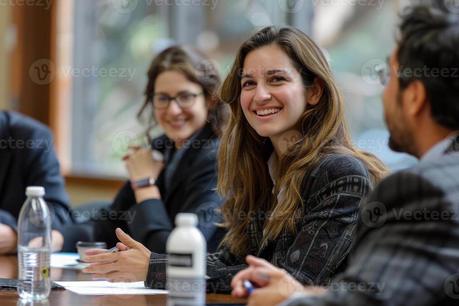 Wide shot of business team talking at meeting table in office conference room, photo