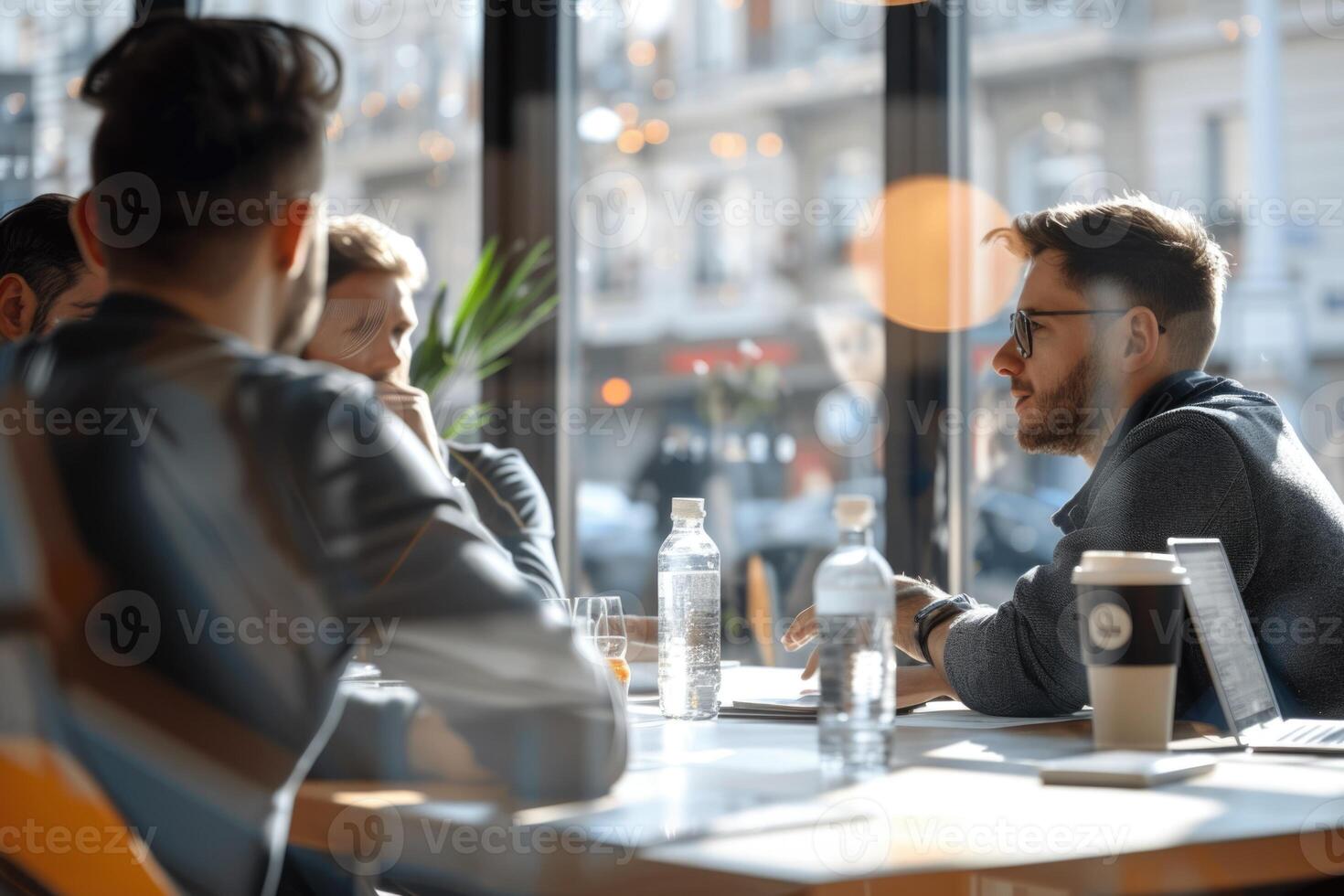 Wide shot of business team talking at meeting table in office conference room, photo