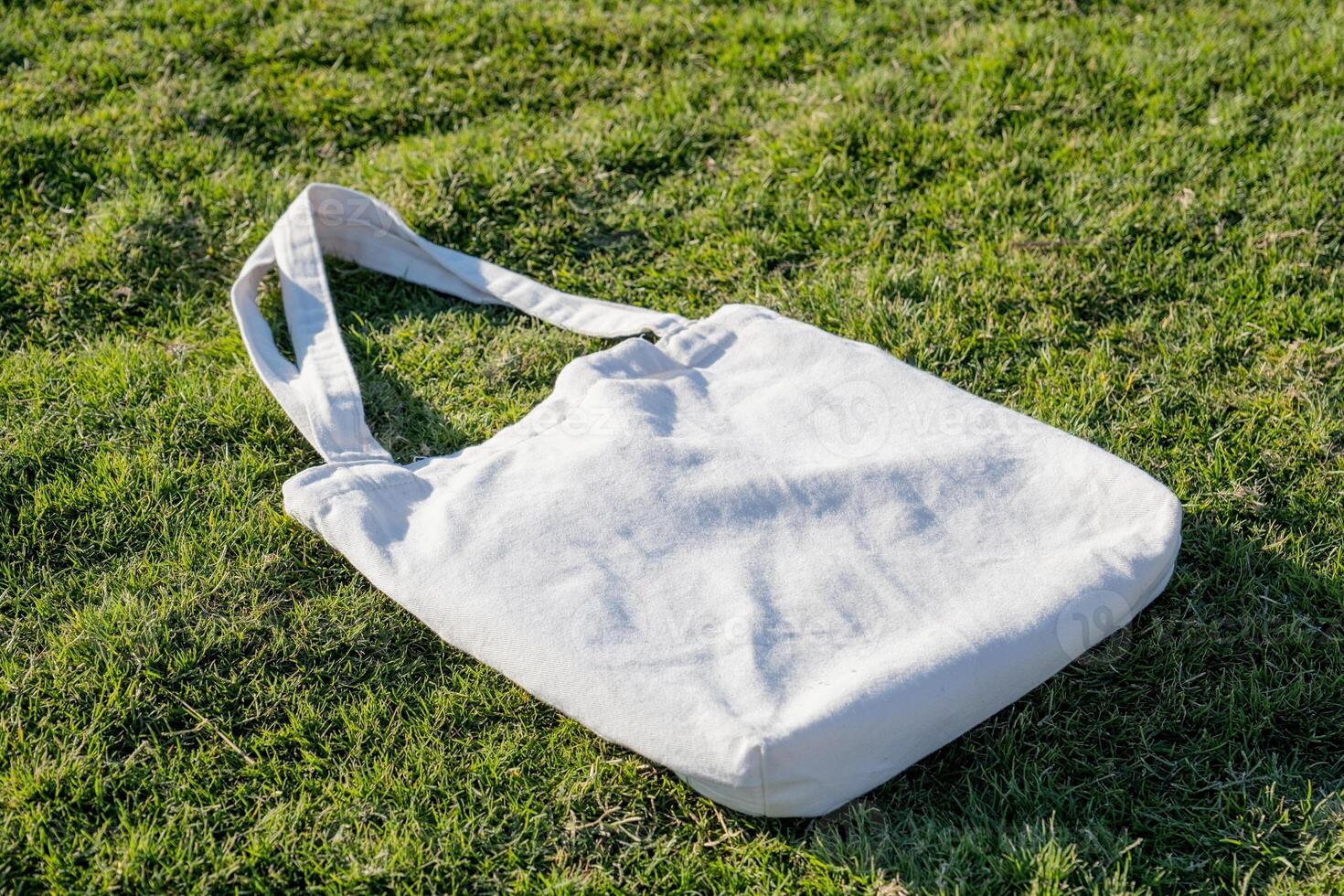 Mockup shopper handbag on green grass background photo