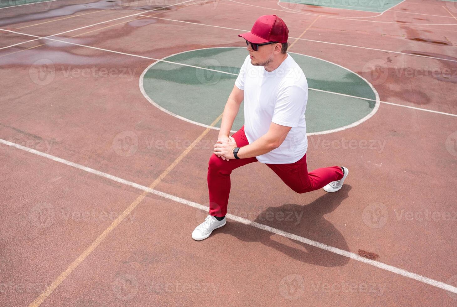 Athletic bearded man warms up before workout at the stadium photo