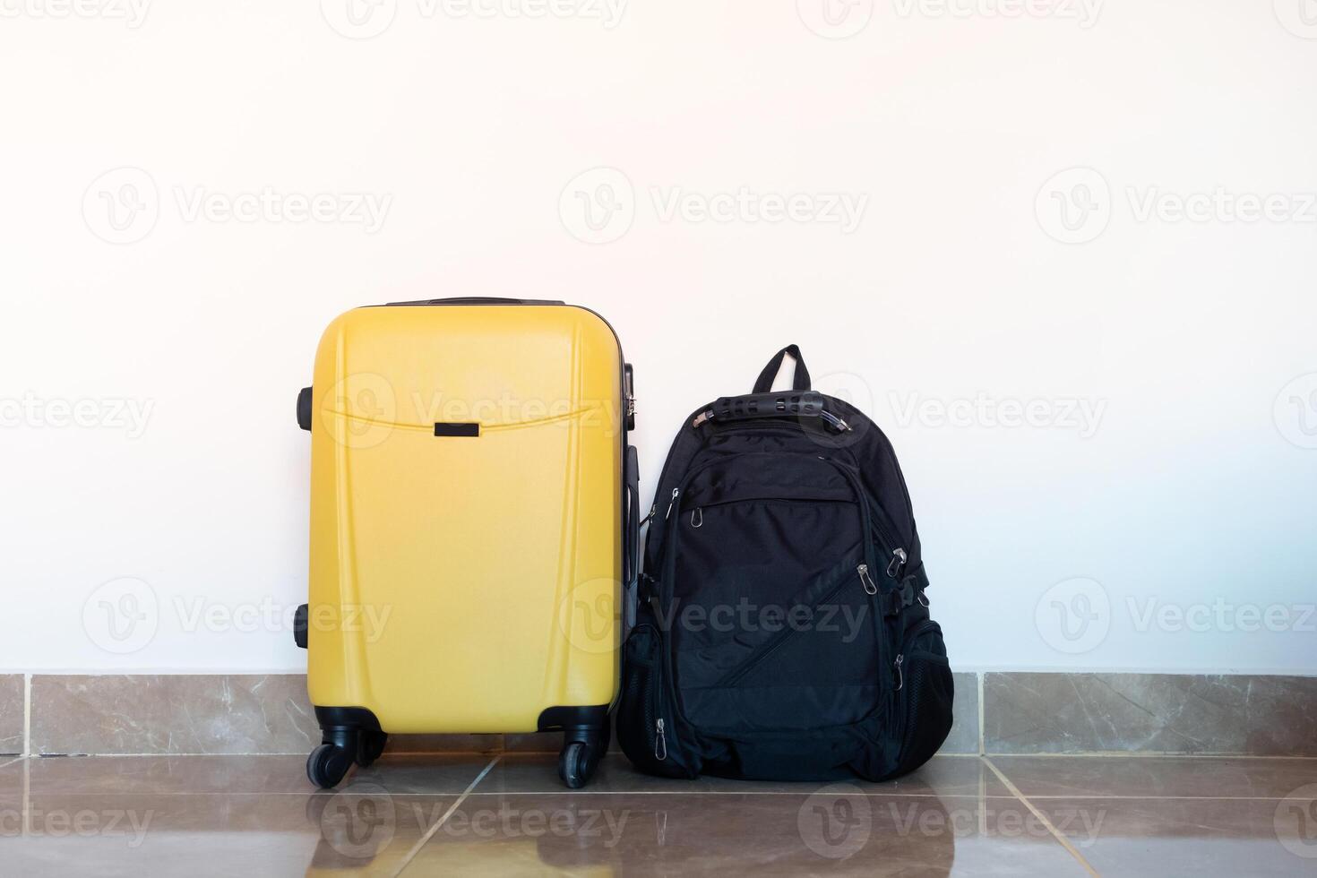 yellow suitcase on white wall background in hotel room photo