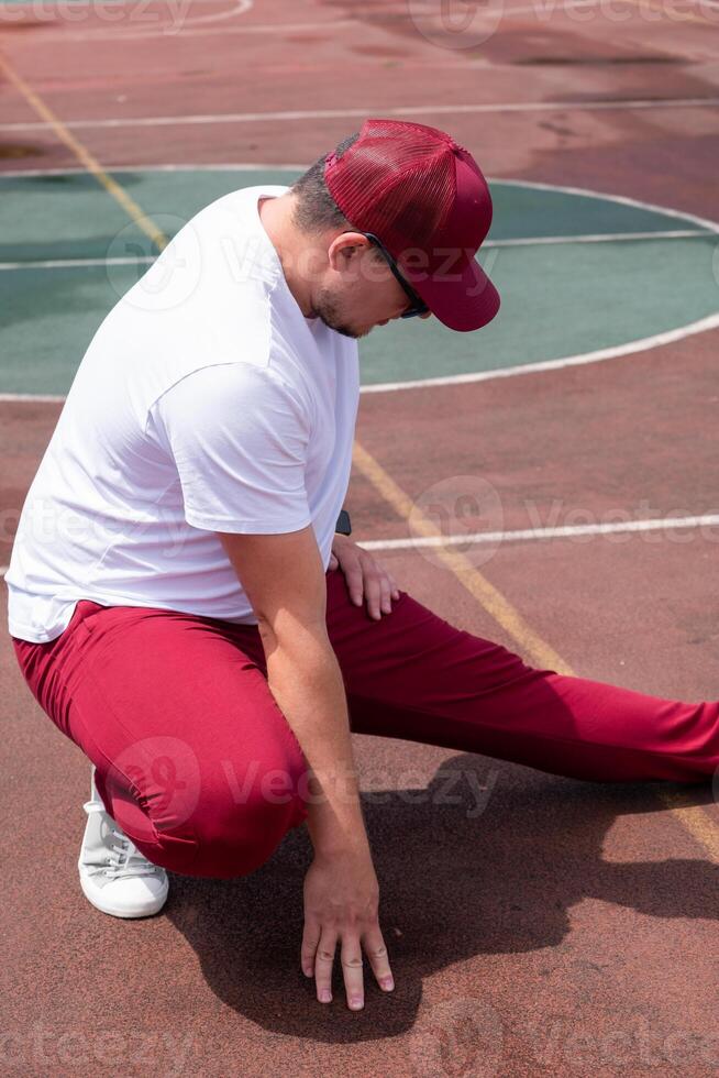 Athletic bearded man warms up before workout at the stadium photo